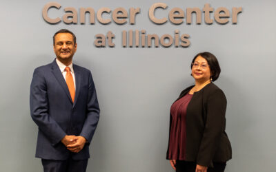 Photo of Rohit Bhargava and Georgina Cheng in front of Cancer Center at Illinois sign